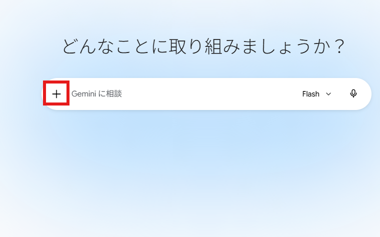 薄い水色の背景に「どんなことに取り組みましょうか?」と表示されたGeminiの入力画面。入力欄の左側に赤枠で強調された「+」ボタンがあり、右側にFlashのモデル表示とマイクアイコンがある。