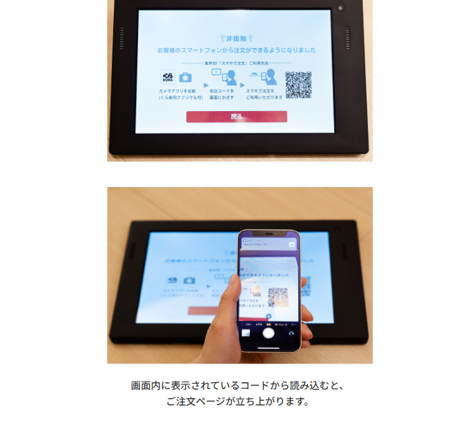 くら寿司のタッチパネルに表示されたスマホ注文用コードを、スマートフォンのカメラで読み取っている様子。
